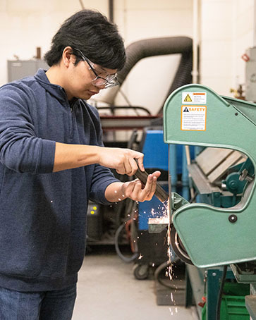 A PNW student works on a machine