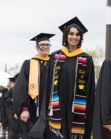 PNW graduate students on during a commencement ceremony. They are wearing their commencement regalia.