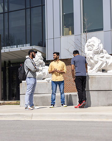 Three PNW students stand outside together