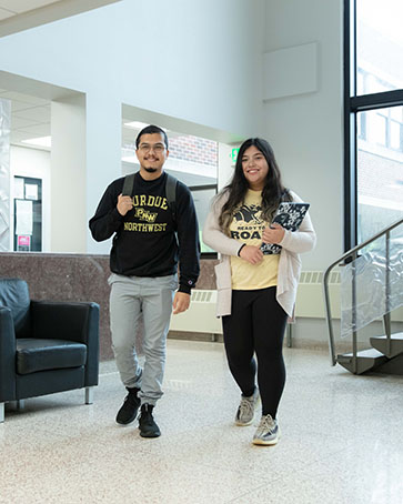 Two students walk down a hallway