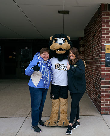 Two staff pose with Leo