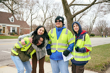 Four Honors College students pose in yellow, reflective work vests