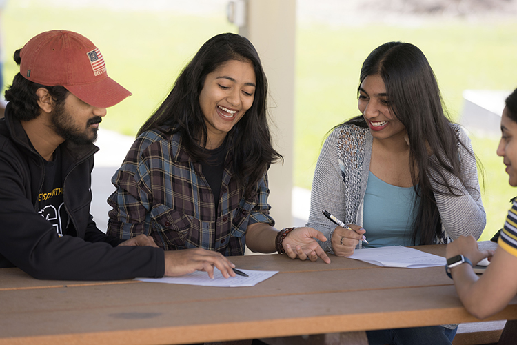 Three students looking at a paper