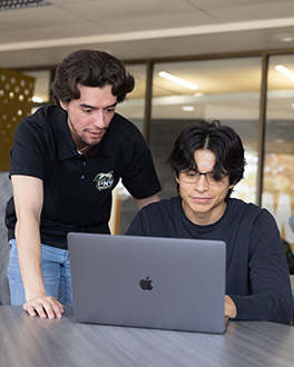 two people looking at a computer in the student lounge