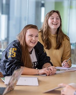 Two students laughing with papers in front of them
