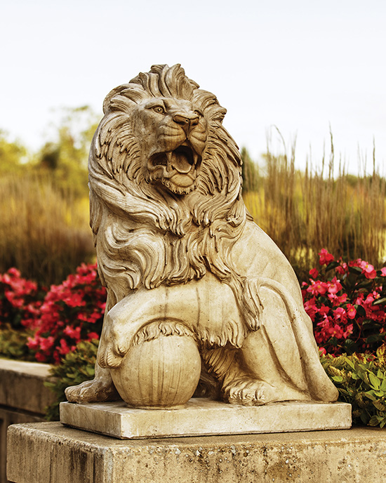 A lion statue on the Westville campus. The statue is surrounded by pink flowers