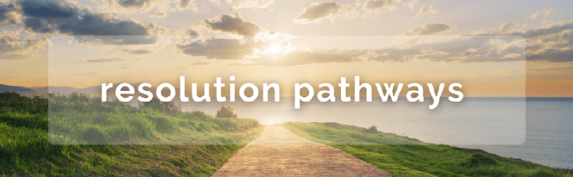 a paved pathway next to a body of water. Each side of the path is green grass. The sun is setting. Text reading "resolution pathways" is overlaying the middle of the image.