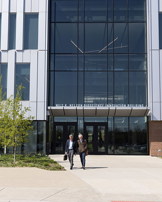 Two people walk out of the Nils Bioscience Building on PNW's Hammond Campus