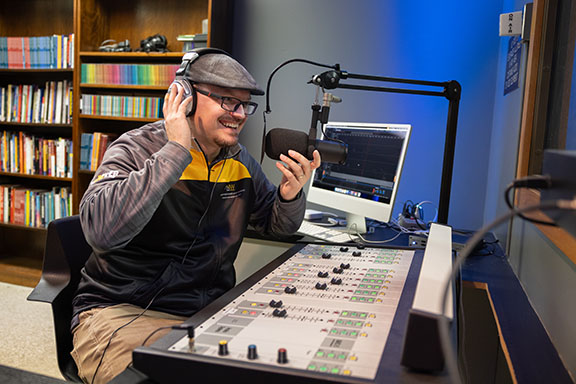 A PNW staff member at work in the audio studio.