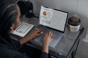 Person typing at computer with graph displayed at desk