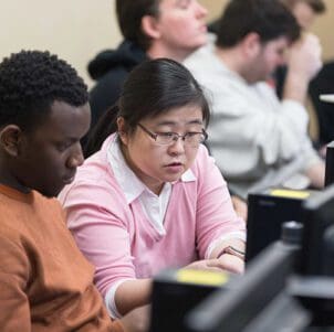Colleagues collaborate at a computer
