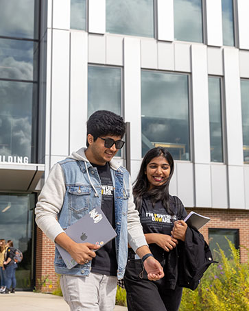 Two students walk outside of the Nils Bioscience building