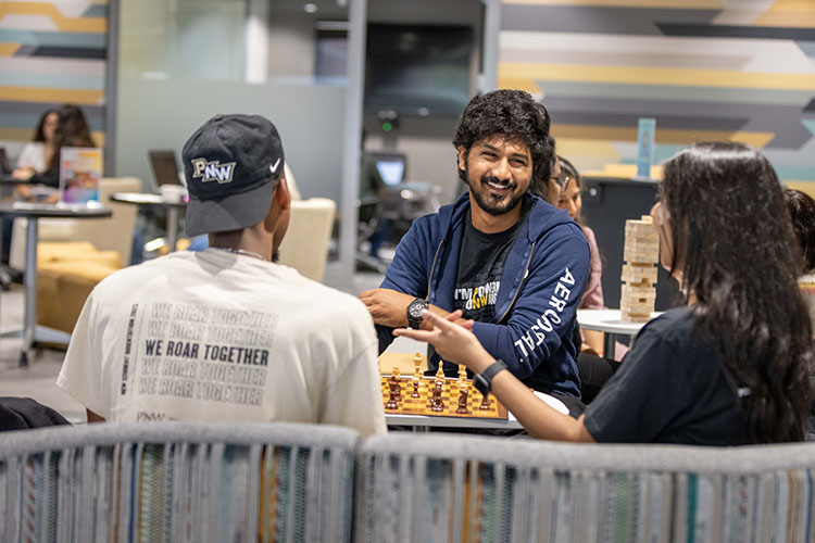 Three students sit in the PNW Mane Zone