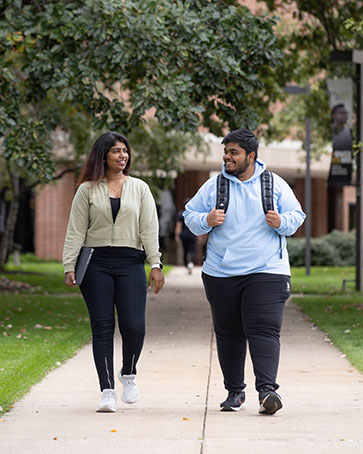 Two students walk down a sidewalk on the PNW Hammond Campus