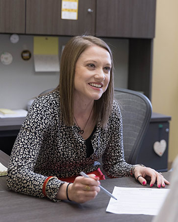 A Career Center employee sits behind their desk and smiles