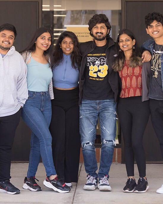 Six students pose together with their arms wrapped around each other.