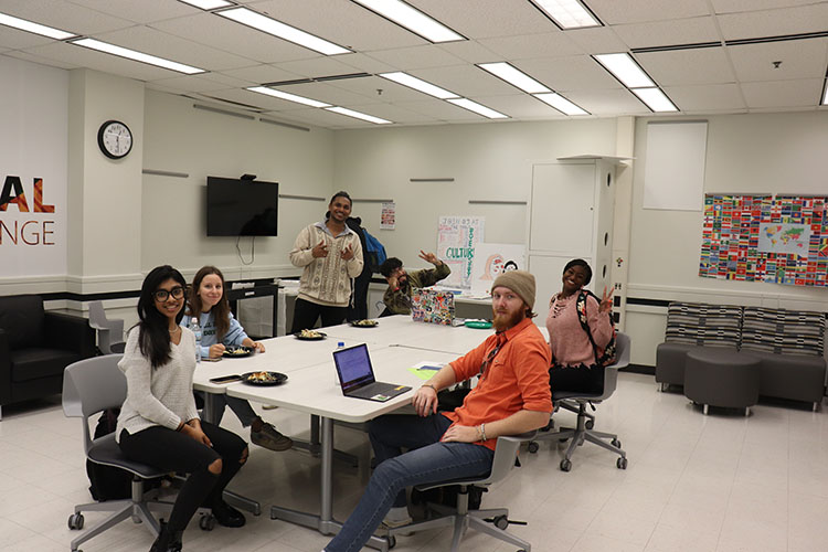 Students sit around a table in the multicultural lounge.