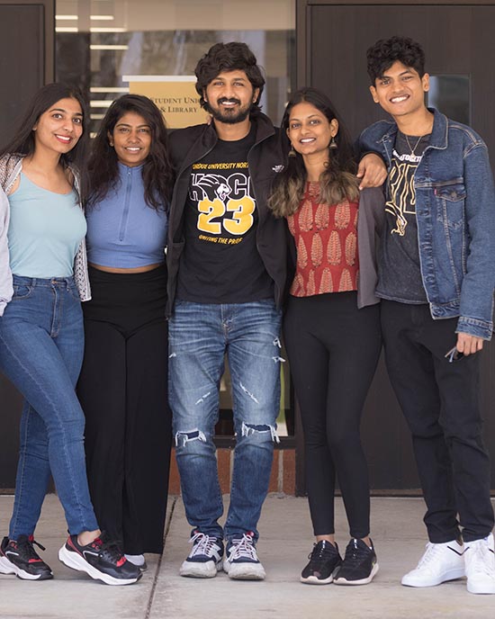 Six students pose together with their arms wrapped around each other.