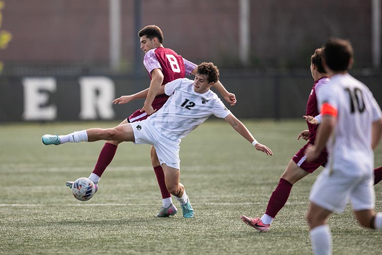 Men's PNW Soccer team kicking the ball at the Homecoming Sports Fest.