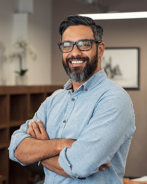 A man in glasses smiles in an office