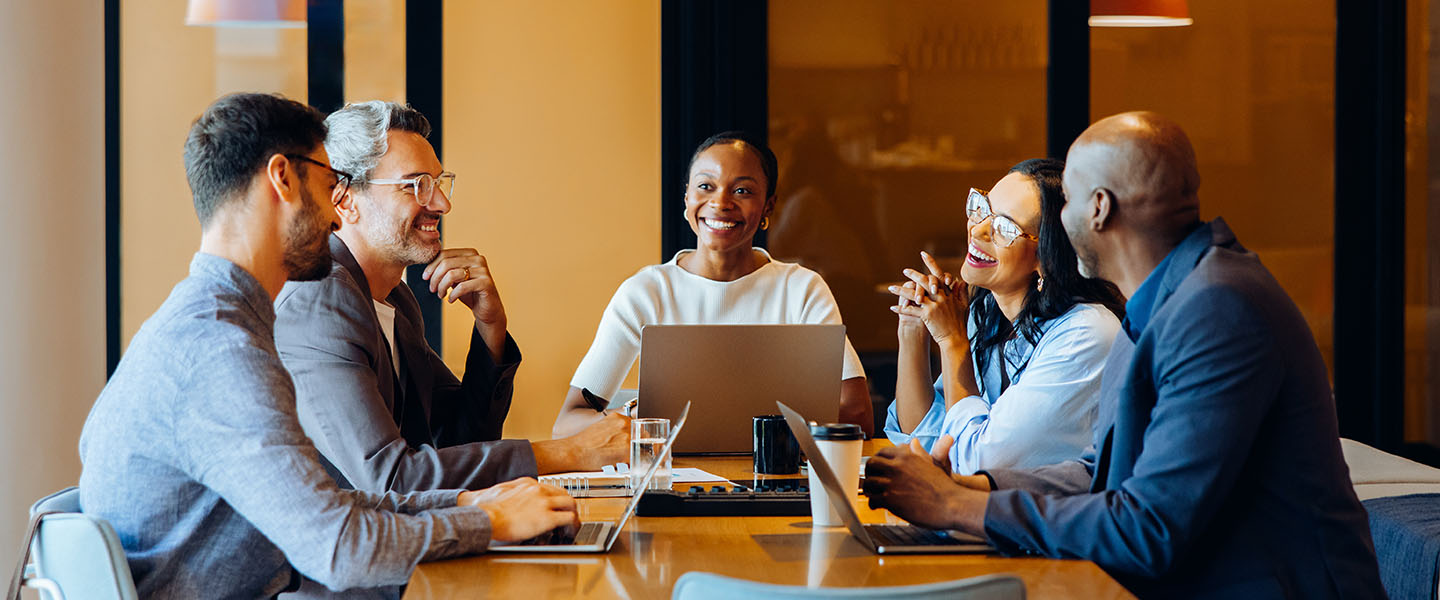 A diverse group of professionals sharing ideas in an office environment during a meeting.