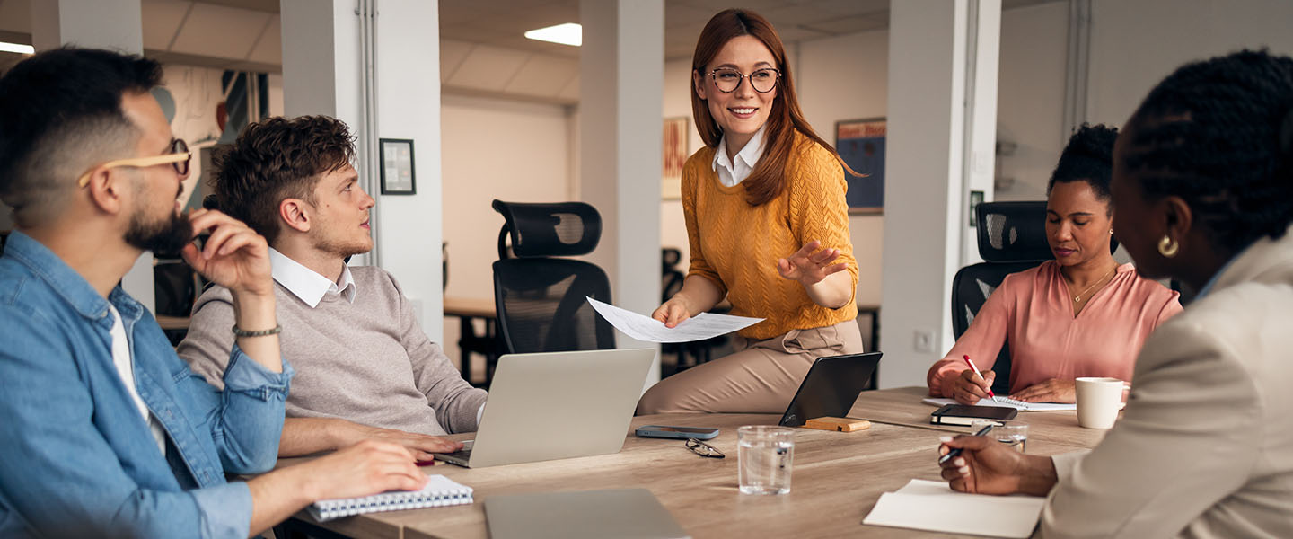 Professional team members engaging in discussion and collaboration during a business meeting at the workplace.