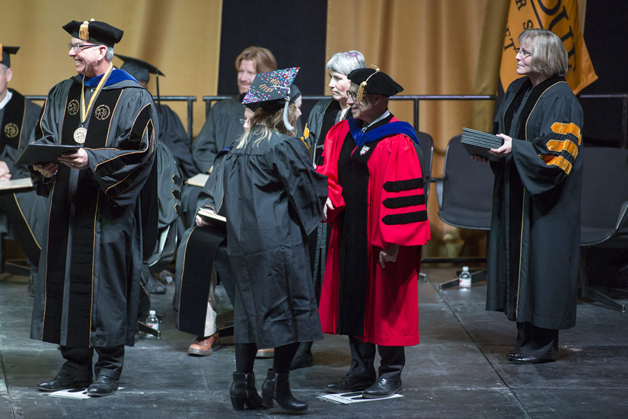 Chancellor Thomas L. Keon presenting students with their diplomas