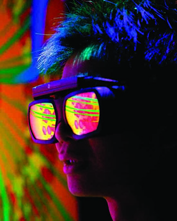 A person wearing reflective goggles looks at a blast furnace simulation