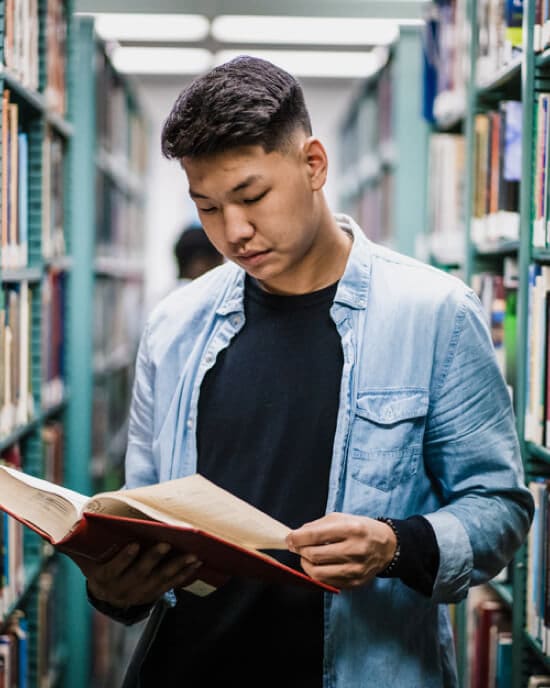 A student reads a book in the PNW library