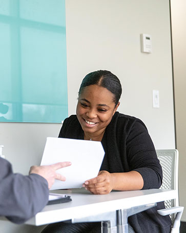 A student smiles while being handed a paper