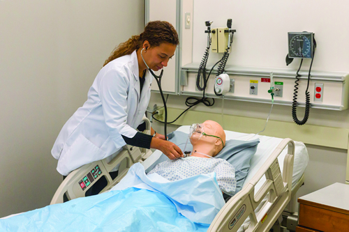 Nursing student checking SimMan's vital signs