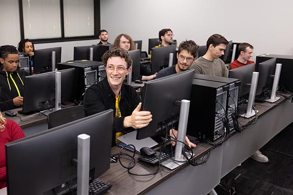 PNW students sitting at the desk in front of computers in a computer lab