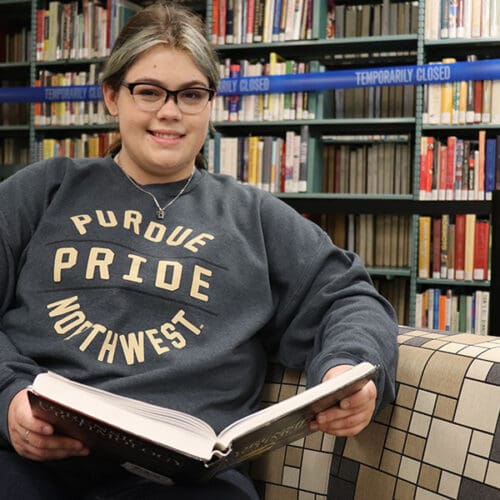 PNW student Victoria Archuleta reads a book in the library