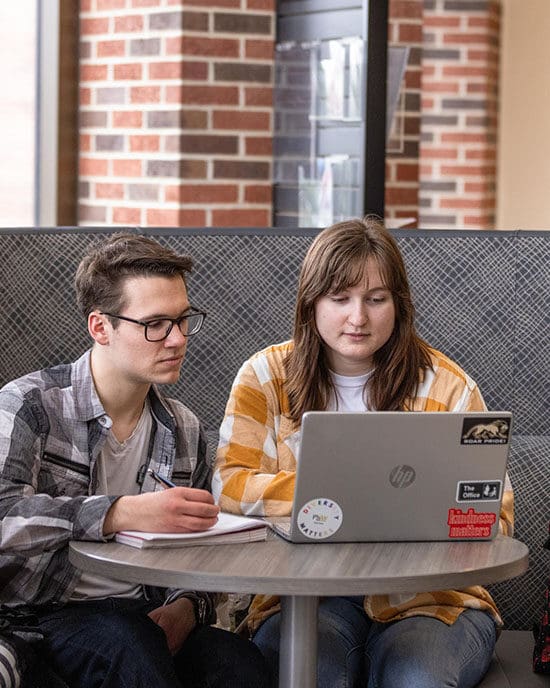 PNW students sit behind a laptop in a cafe.