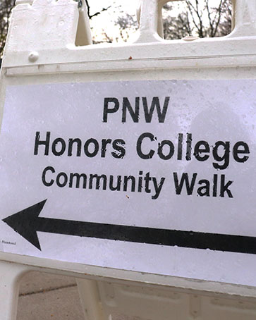 Sign with an arrow saying, "PNW Honors College Community Walk"