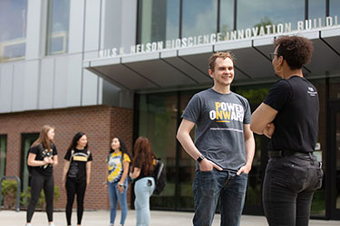 Students in PNW gear stand in front of Purdue Northwest's Nils K. Nelson Bioscience Innovation Building