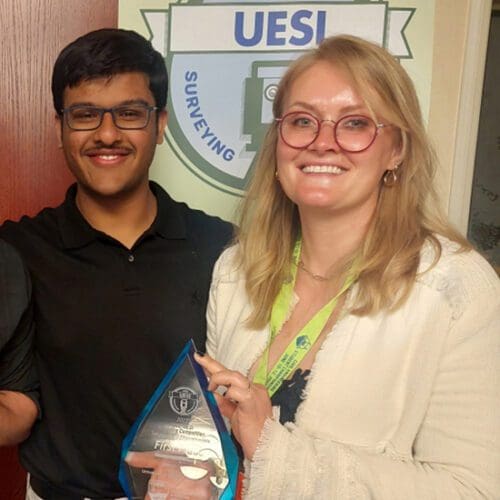 Two students pose with a trophy