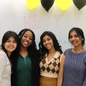 Four students pose together during an international womens day event.
