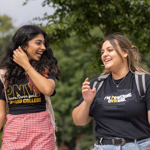 Two students walk outdoors