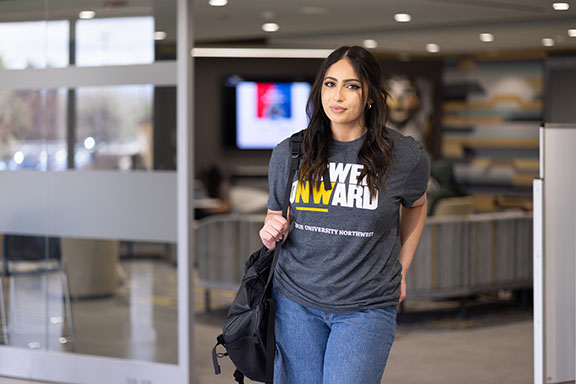 A student poses in a gray t-shirt that says "Power Onward".