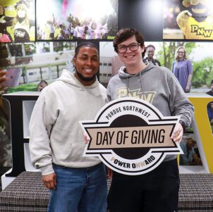 PNW students pose with a PNW Day of Giving sign.