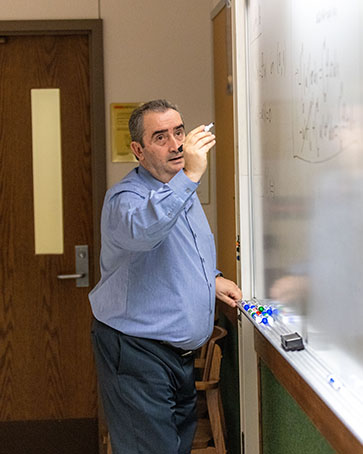 Nicolae Tarfulea writes on a dry erase board