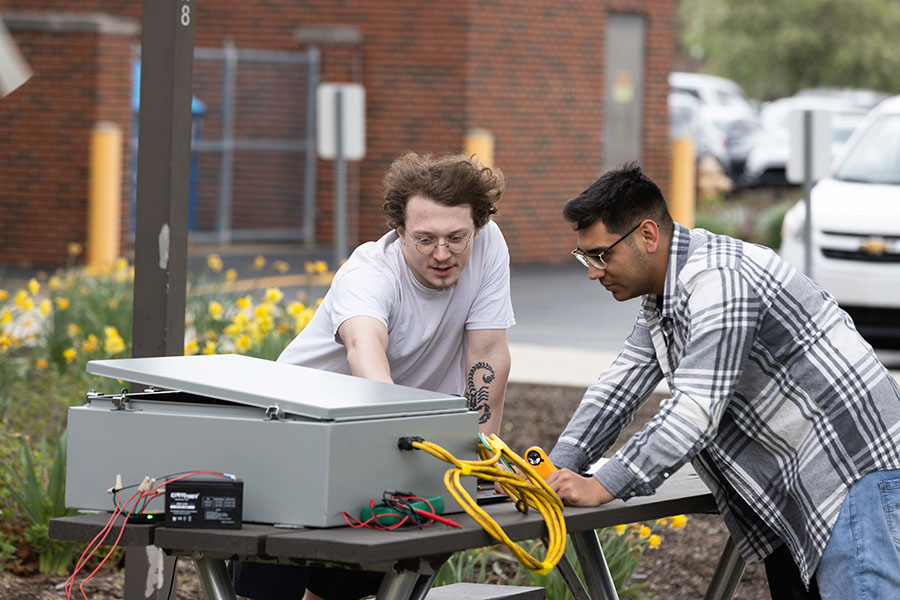 Students work on a wind energy capstone project outdoors.