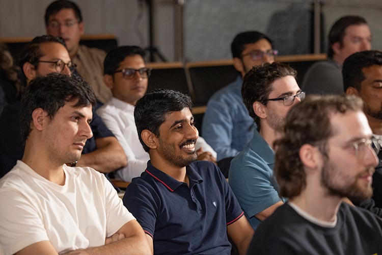 Students sitting in chairs and smiling during class 