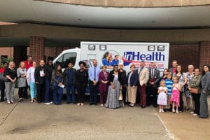 Staff members pose in front of a hospital