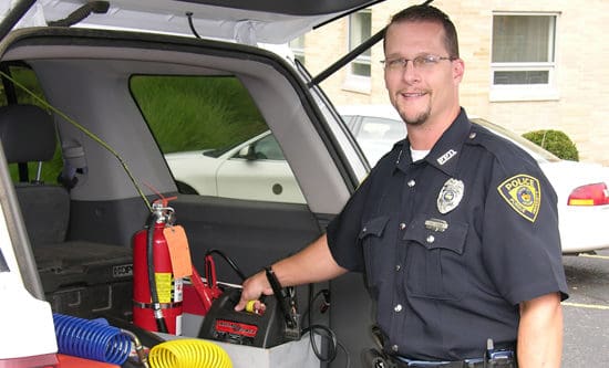 Police officer getting ready to jump start a car