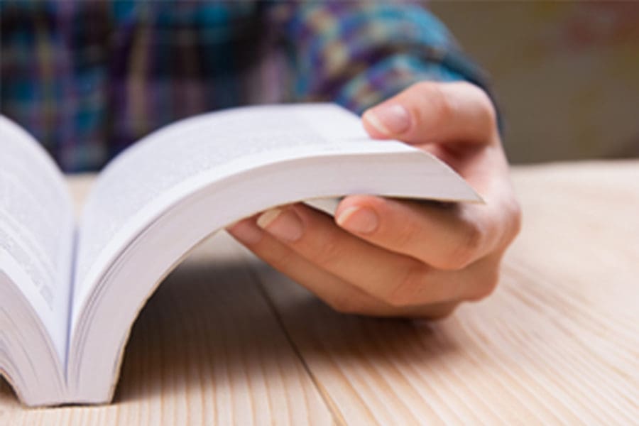 Student hands on book close up