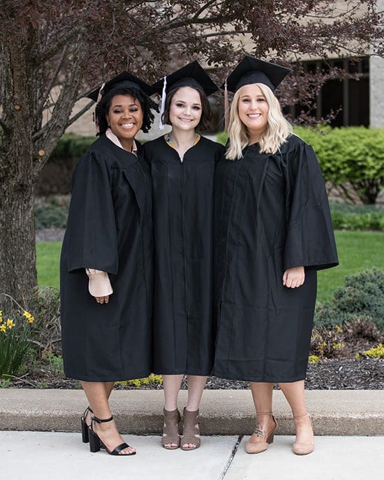 PNW graduates pose together in caps and gowns