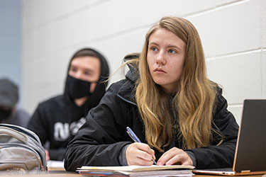 A PNW student takes notes in the classroom