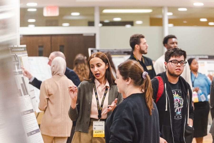 Attendees walk around and look at presentations